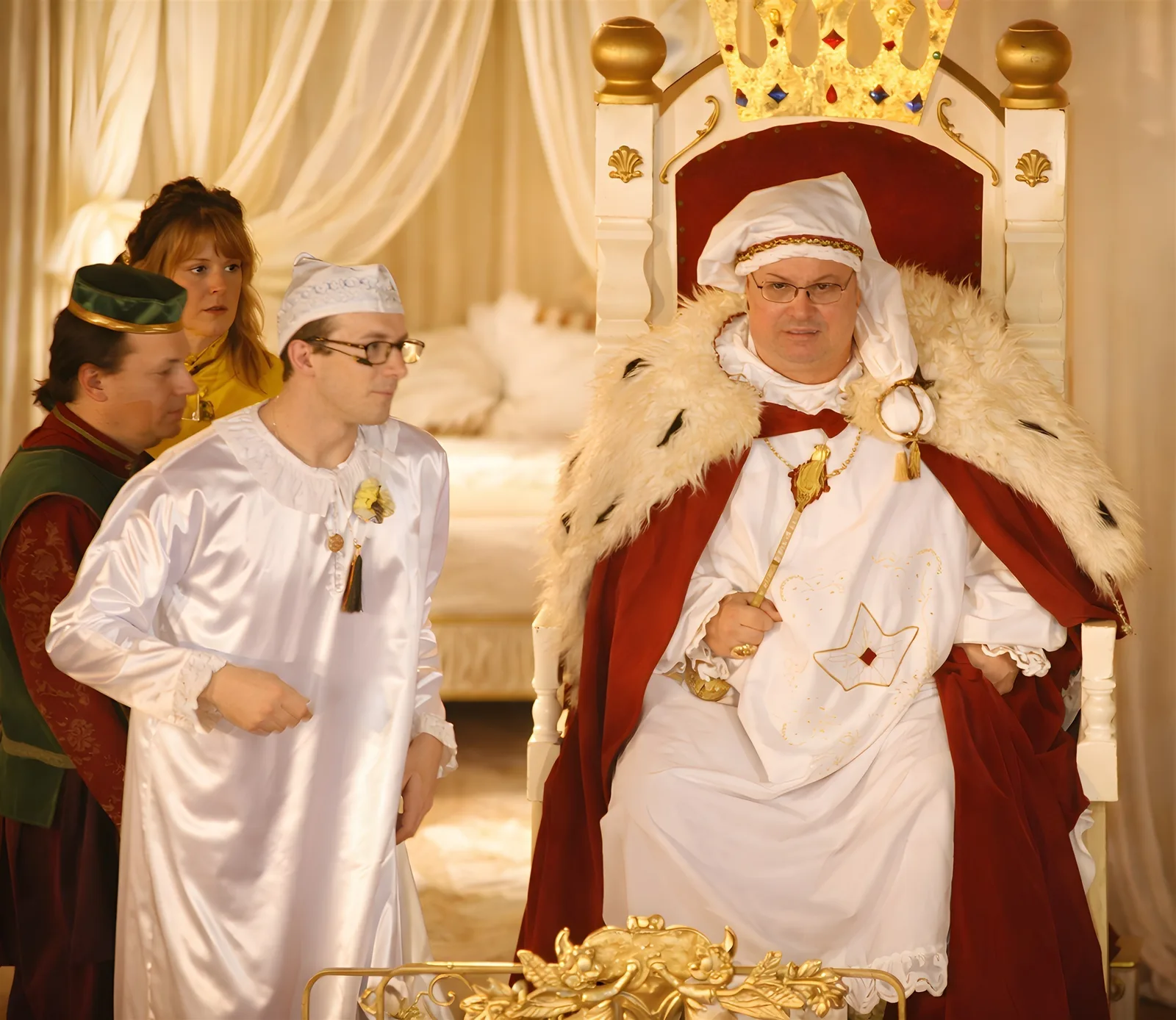 Königliche Beratung im Schlafzimmer ? Der König im weißen Schlafgewand und Hermelin berät sich mit Gefolge im goldenen Bettgemach – Sorge um das Königreich.