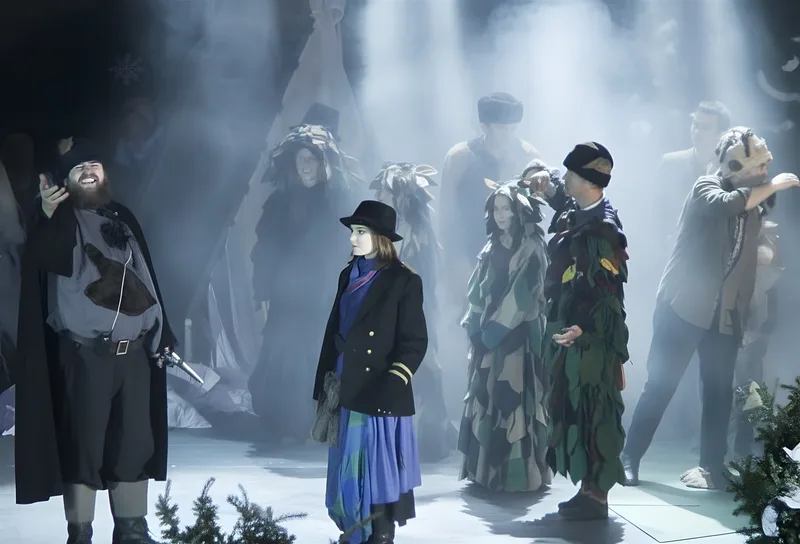 Räuber beraten zwischen Blätterwesen ? Der Räuberhauptmann gestikuliert, während sich Räuber und Büsche im Lichtkegel sammeln – Planung im Märchenwald.