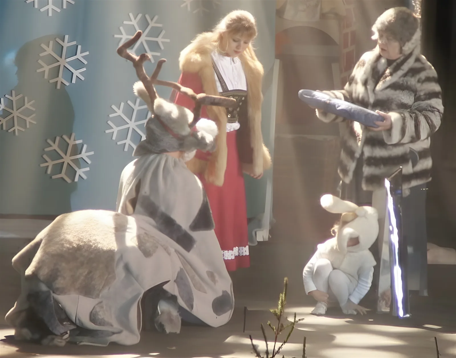 Rentier und Hase bei der Finnin ? Gerda und die Finnin überreichen dem knienden Rentier eine Decke, ein kleiner Hase schaut zu – letzte Stärkung vor dem Palast.