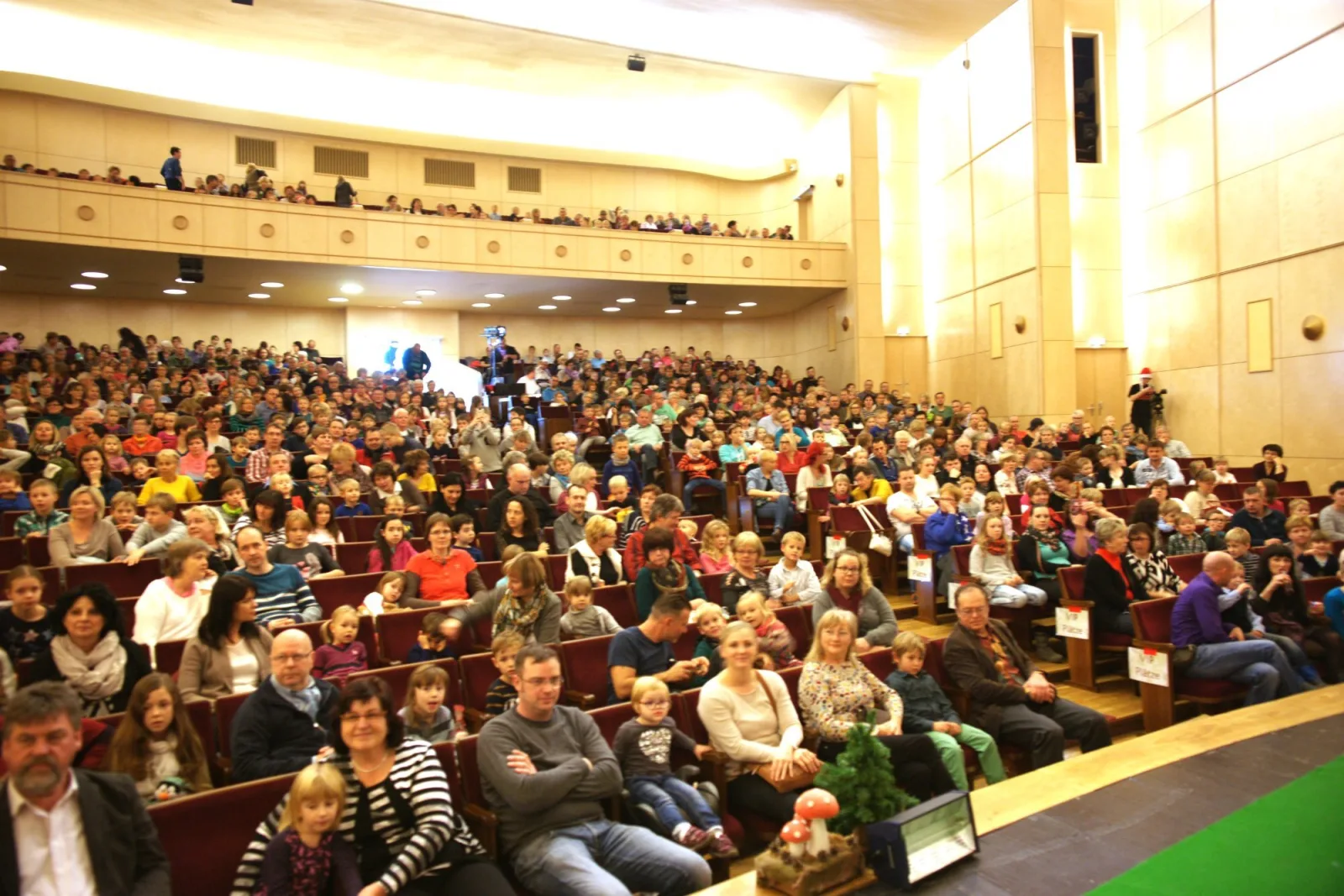 Publikum im ausverkauften Theatersaal – Der große Saal ist bis auf den letzten Platz gefüllt, Familien und Kinder warten gespannt auf das Weihnachtsmusical – fröhliche Erwartung und festliche Stimmung vor der Bühne.