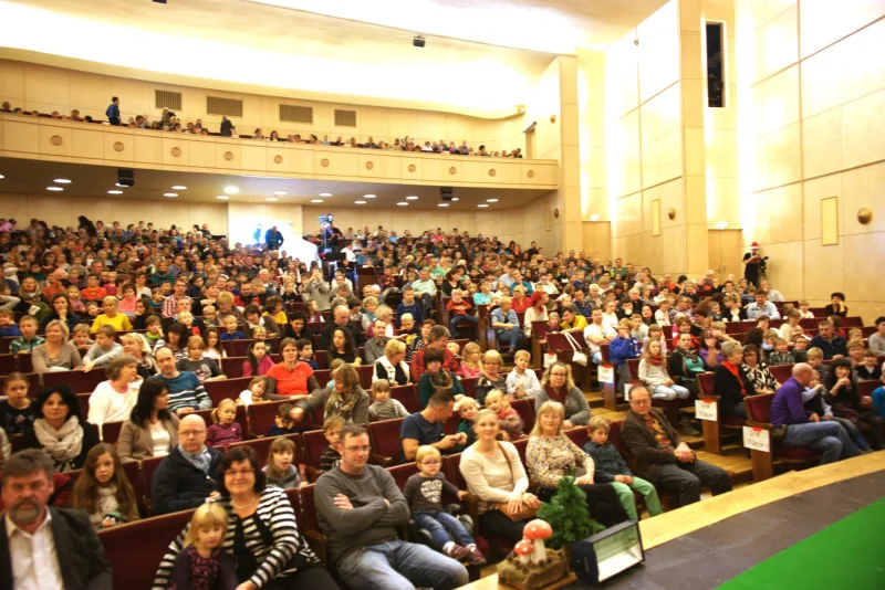 Publikum im ausverkauften Theatersaal – Der große Saal ist bis auf den letzten Platz gefüllt, Familien und Kinder warten gespannt auf das Weihnachtsmusical – fröhliche Erwartung und festliche Stimmung vor der Bühne.