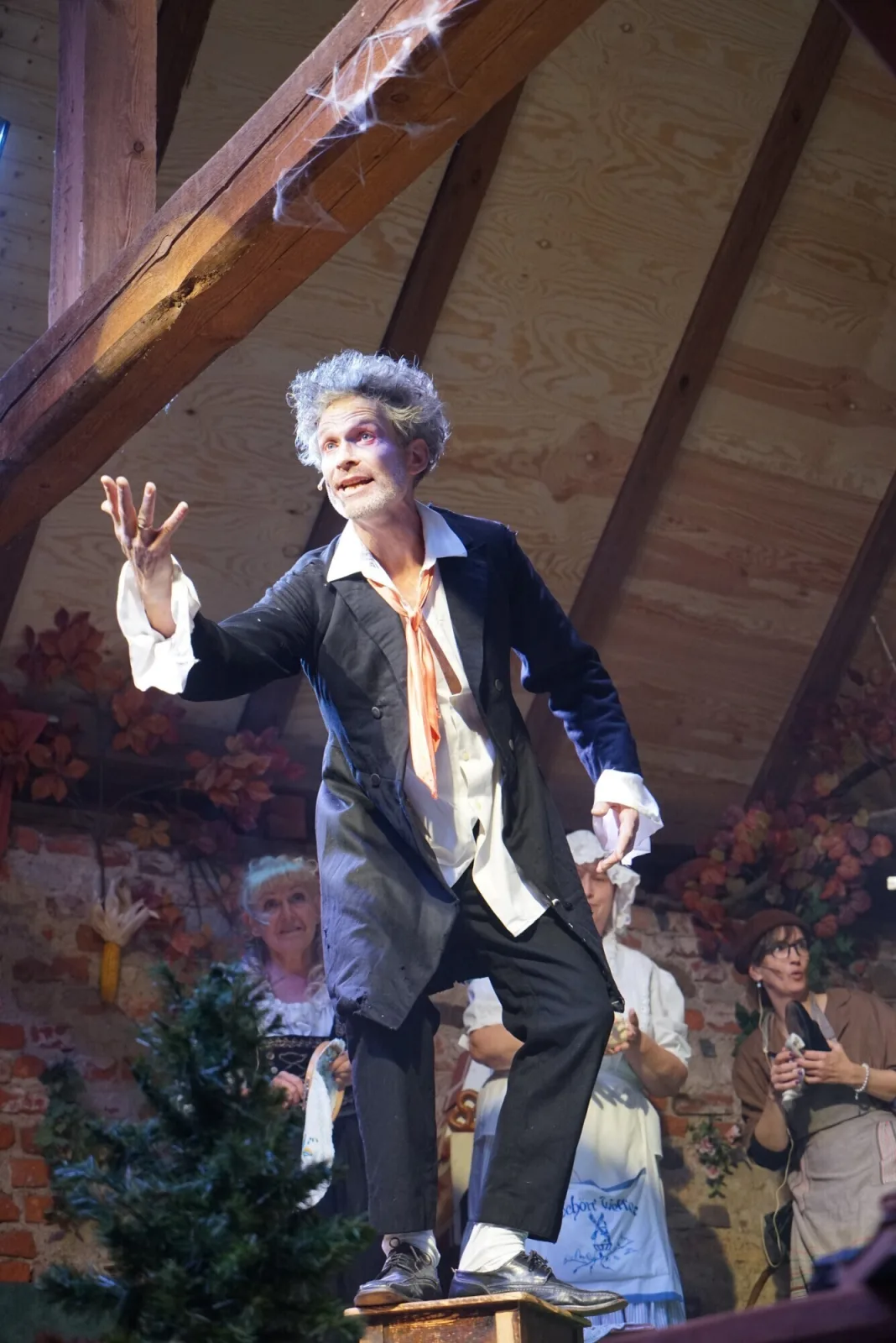 Alter Danius mit leidenschaftlicher Ansprache – Der Schauspieler als Alter Danius steht auf einem Podest und gestikuliert energisch, während Dorfbewohner gebannt zusehen.