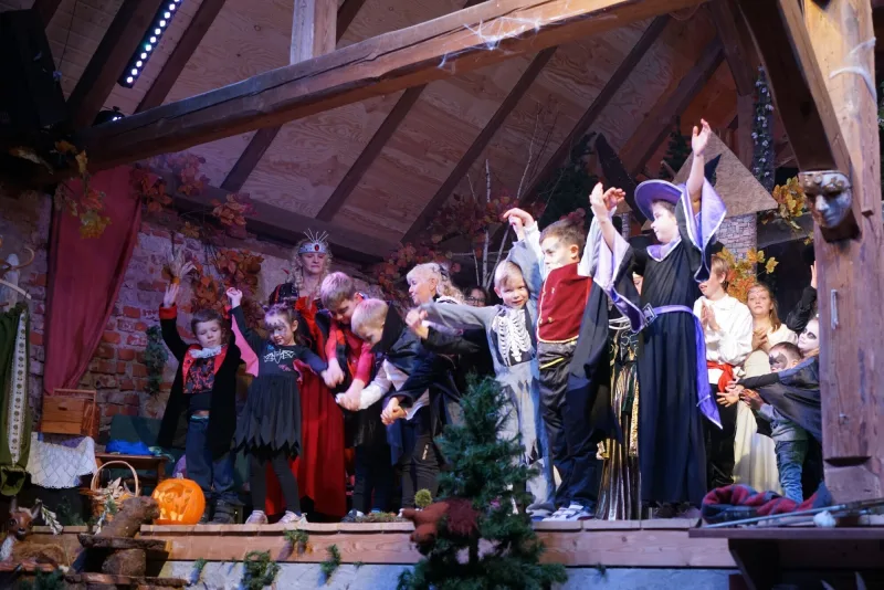 Kindertruppe im Finale des Musicals – Verkleidete Kinder in Vampir- und Hexenkostümen verbeugen sich fröhlich beim Schlussapplaus auf der Bühne.